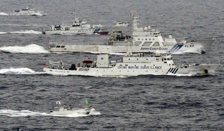 An aerial photo shows a Chinese marine surveillance ship Haijian No. 66 (C) cruising next to Japan Coast Guard patrol ships in the East China Sea, near what are known as the Senkaku isles in Japan and the Diaoyu islands in China, in this photo taken by Kyodo April 23, 2013. REUTERS/Kyodo