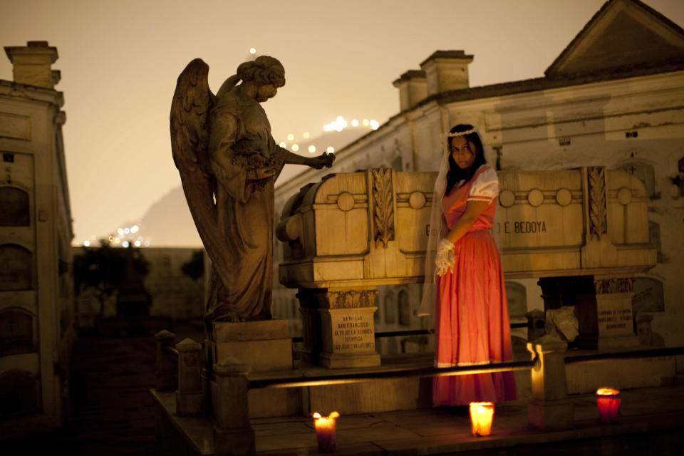 In this Sept. 20, 2012 photo, a performer dramatizes a historic event during a nighttime guided tour through the Presbitero Matias Maestro cemetery in Lima, Peru. Visitors to the 54-acre cemetery just 20 blocks from Lima's presidential palace, one of Latin America's oldest, are treated to tales about the people buried here in a three-hour, nighttime guided tour run by its owner, Beneficiencia de Lima (AP Photo/Rodrigo Abd)