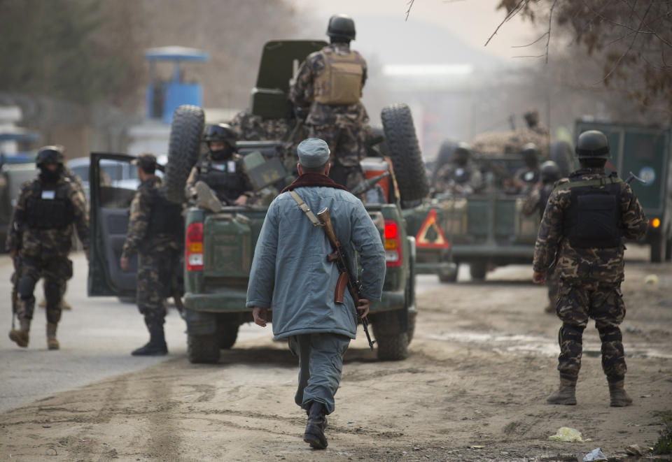 Afghan police and commandos with Afghanistan's intelligence agency arrive after four suicide bombers armed with assault rifles and hand grenades attacked an “office of foreigners” in a southwestern neighborhood of Kabul, Afghanistan, Friday, March 28, 2014. A Taliban spokesman said insurgents attacked a “guest house of foreigners and a church of foreigners.” His claim could not be immediately confirmed. (AP Photo/Anja Niedringhaus)