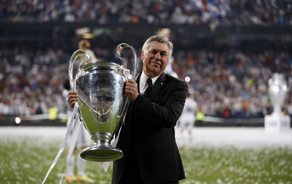 Real Madrid's coach Carlo Ancelotti poses with  the Champions League trophy during a victory ceremony at Santiago Bernabeu stadium in Madrid May 25, 2014. Real Madrid won its 10th Champions League title after beating Atletico Madrid in the final match in Lisbon.    REUTERS/Paul Hanna (SPAIN  - Tags: SPORT SOCCER)  