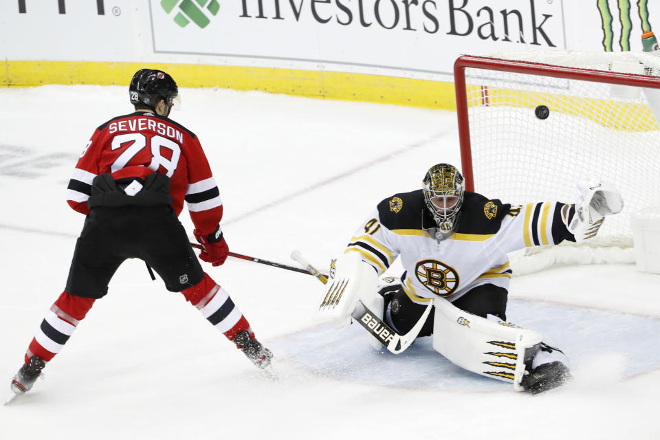 New Jersey Devils defenseman Damon Severson (28) gets his shot past Boston Bruins goaltender Jaroslav Halak (41) for a goal and the victory in a shootout in an NHL hockey game, Tuesday, Dec. 31, 2019, in Newark, N.J. The Devils defeated the Bruins 3-2 in the shootout on Severson's game-deciding goal. (AP Photo/Kathy Willens)