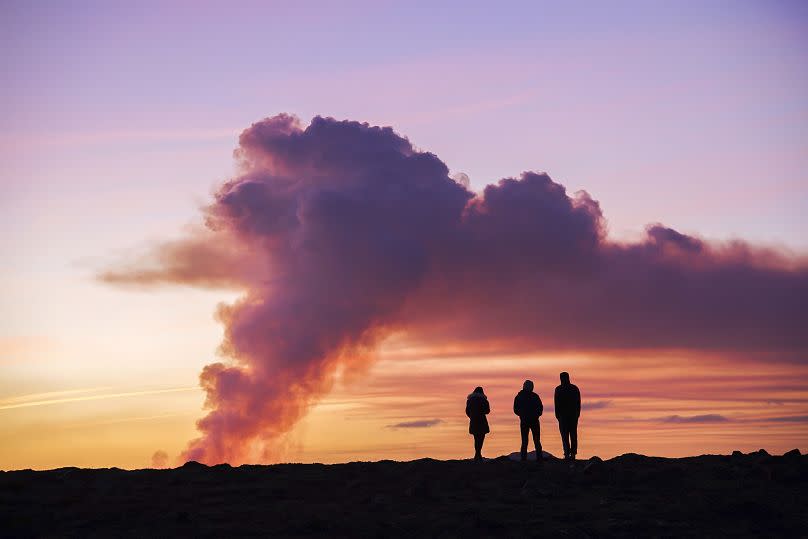 La gente observa desde el norte la erupción del volcán cerca de Grindavík, Islandia, el domingo 14 de enero de 2024.