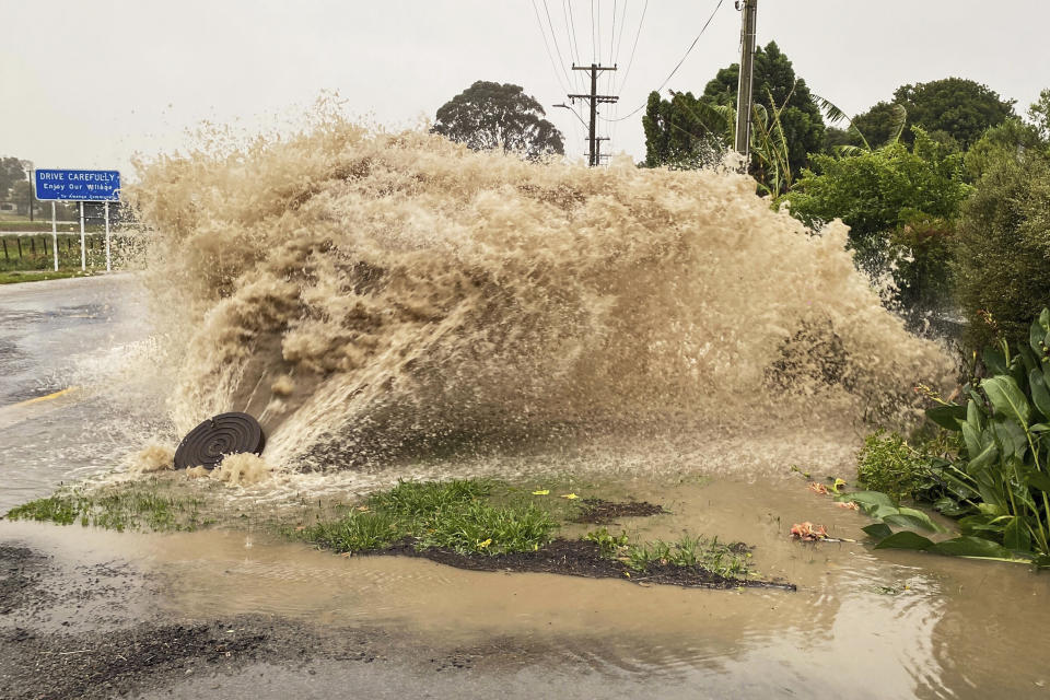 Water gushes from a storm drain access port on a street in Te Awanga, southeast of Auckland, New Zealand, Tuesday, Feb. 14, 2023. The New Zealand government declared a state of emergency across the country's North Island, which has been battered by Cyclone Gabrielle. (Warren Buckland/Hawkes Bay Today via AP)