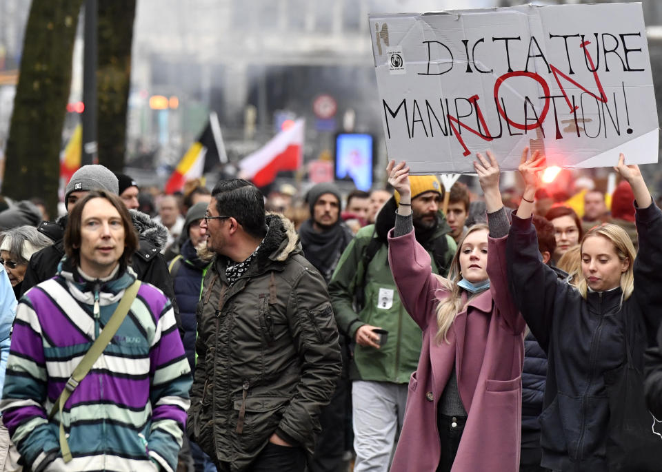 Demonstrators march during a protest against coronavirus measures in Brussels, Belgium, Sunday, Dec. 5, 2021. Hundreds of people marched through central Brussels on Sunday to protest tightened COVID-19 restrictions imposed by the Belgian government to counter the latest spike in coronavirus cases. (AP Photo/Geert Vanden Wijngaert)