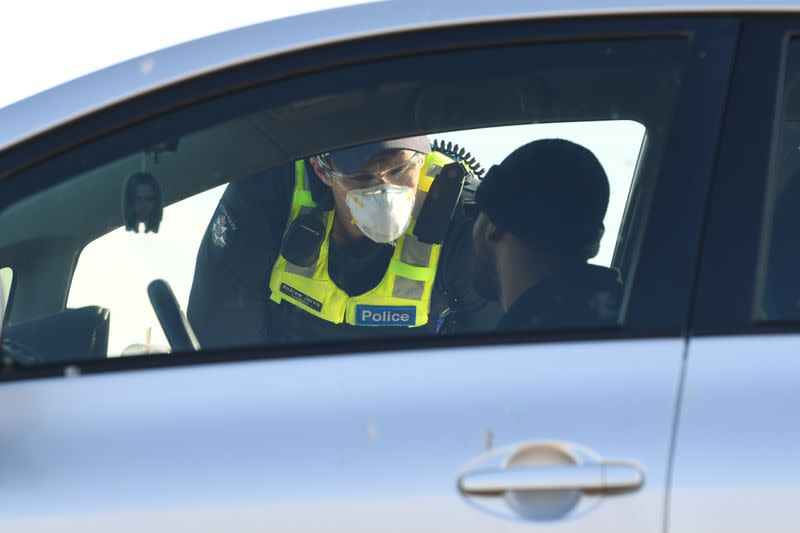 FILE PHOTO: A Victoria Police officer works at a vehicle checkpoint created in response to an outbreak of COVID-19 near Melbourne