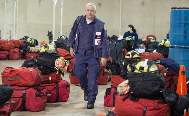 A member of Virginia Task Force 1, Fairfax Urban Search and Rescue Team walks among the packed bags of search and rescue members at their Chantilly, Virginia headquarters, before deploying to Nepal on April 25, 2015