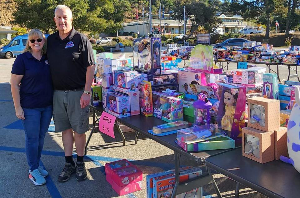 Dave Ehlers, right, is the Cambria Chamber of Commerce’s 2023 Citizen of the Year. He and wife Jennifer “Jenn” Ehlers stand in front of just part of this year’s donations for Toys for Tots, one of several nonprofits, groups and volunteer endeavors that earned him the honor.