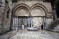 A man stands in front of the closed doors of the Church of the Holy Sepulchre on Good Friday amid the coronavirus disease (COVID-19) outbreak, in Jerusalem's Old City