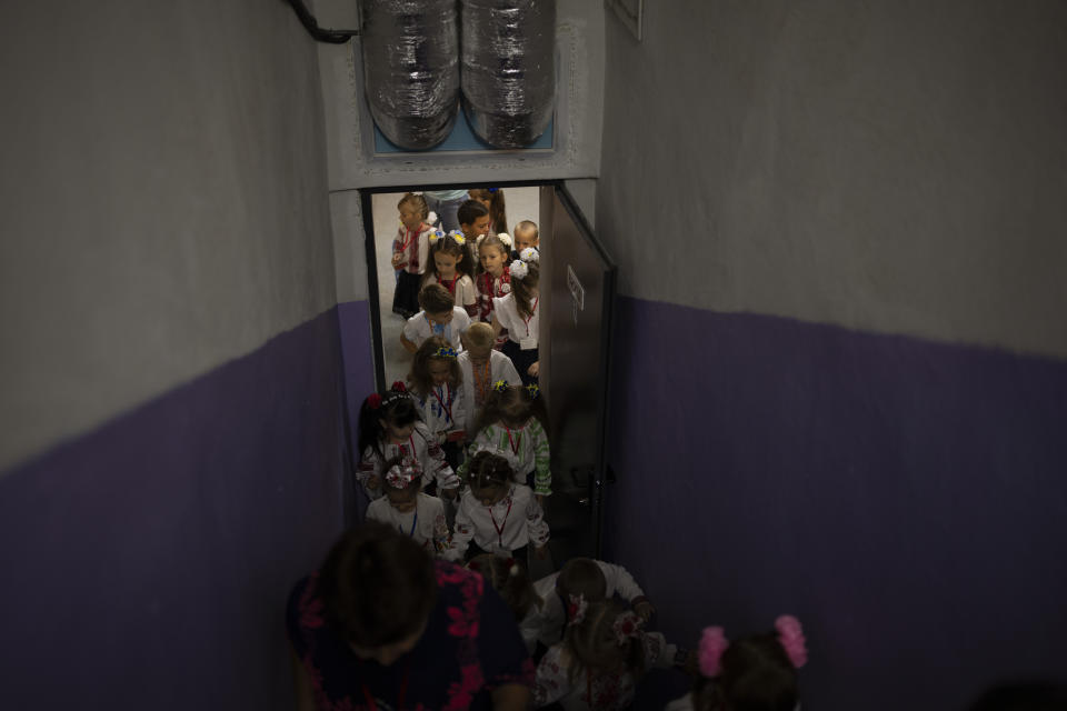 Students leave a shelter after an evacuation training during their first day of school at a public school in Irpin, Ukraine, Thursday, Sept. 1, 2022. Ukrainian children return to school without sharing memories from their holidays. They share stories of how they survived the first months of the war. For many children, last semester finished the day before Russia invaded Ukraine on the 24th of February. The ongoing war remains the biggest challenge for the educational system of Ukraine. (AP Photo/Emilio Morenatti)