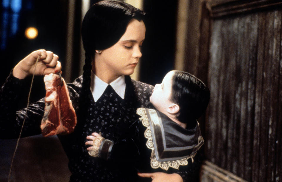 Christina Ricci dangling meat in a scene from the film 'Addams Family Values', 1993