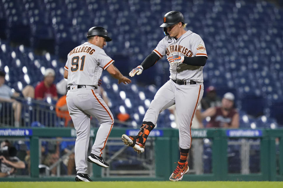 San Francisco Giants' Joc Pederson, right, and third base coach Mark Hallberg celebrate after Pederson's two-run home run during the 11th inning of a baseball game against the Philadelphia Phillies, Tuesday, May 31, 2022, in Philadelphia. (AP Photo/Matt Slocum)