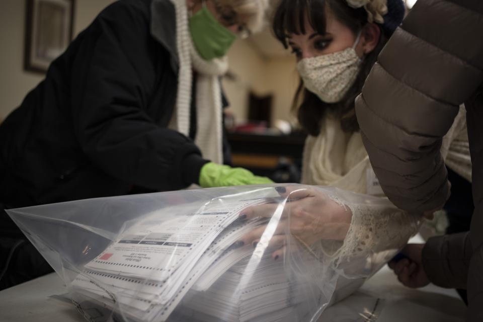 In this Nov. 3, 2020, photo, election staff members pack ballots after polls closed at the Moose Lodge on Election Day in Kenosha, Wis. President-elect Joe Biden shored up the Democrats' “blue wall,” — more sturdily in Michigan, more tenuously in Pennsylvania and Wisconsin — to rebuild the party's path back to the White House. (AP Photo/Wong Maye-E, File)