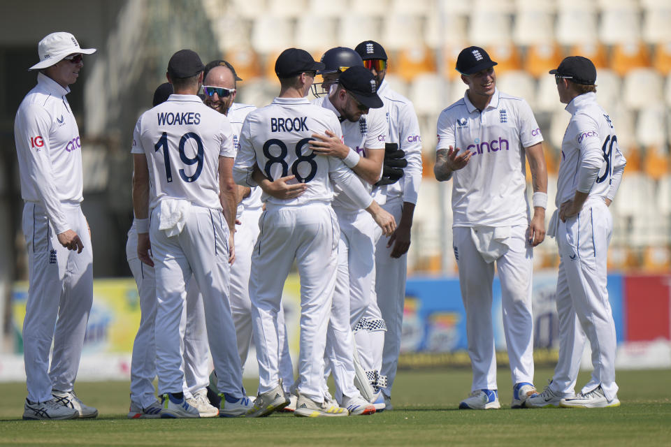 England's Jack Leach, center in glasses, celebrates with teammates after taking the wicket of Pakistan's Salman Ali Agha during the fifth day of the first test cricket match between Pakistan and England, in Multan, Pakistan, Friday, Oct. 11, 2024. (AP Photo/Anjum Naveed)