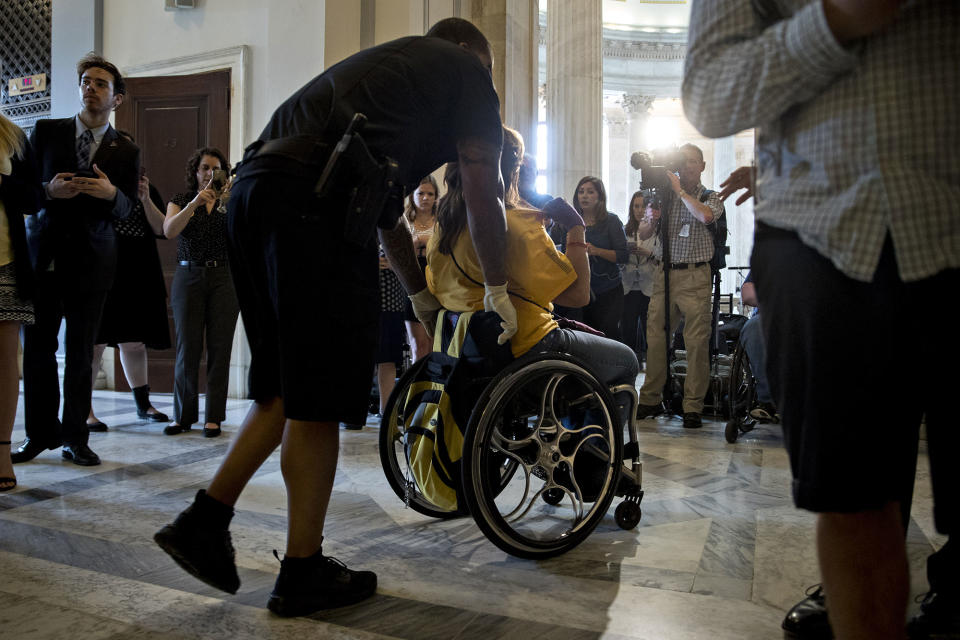 <p>A demonstrator in a wheelchair protesting cuts to Medicaid is led from the office of Senate Majority Leader Mitch McConnell by a U.S. Capitol police officer at the Russell Senate Office building in Washington on Thursday, June 22, 2017. (Photo: Andrew Harrer/Bloomberg via Getty Images </p>