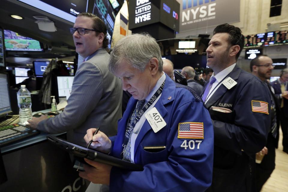 Richard Newman, center, works with fellow traders on the floor of the New York Stock Exchange, Tuesday, Jan. 17, 2017. Stocks are opening slightly lower on Wall Street, led by declines in banks and health care companies. (AP Photo/Richard Drew)