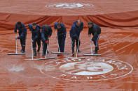 <p>Stadium workers remove rain from a protective cover on center court at the French Open tennis tournament at the Roland Garros stadium in Paris, France, Tuesday, May 31, 2016. Persistent rain delayed the start of play. (AP Photo/Michel Euler) </p>