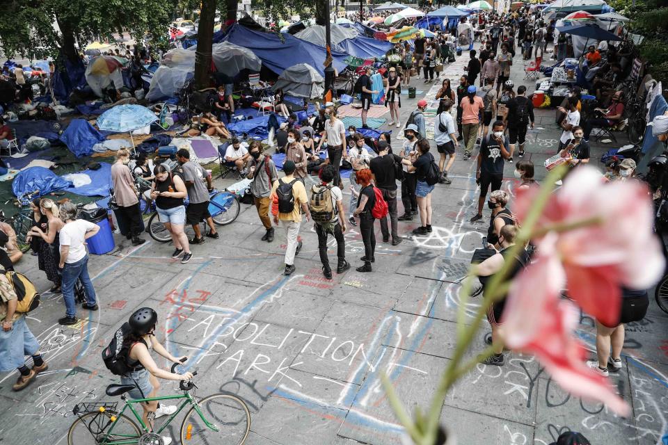 Protesters gather at an encampment outside City Hall, Tuesday, June 30, 2020, in New York. New York City lawmakers are holding a high-stakes debate on the city budget as activists demand a $1 billion shift from policing to social services and the city grapples with multibillion-dollar losses because of the coronavirus pandemic. (AP Photo/John Minchillo)