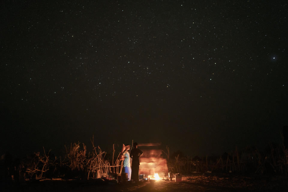 Women stand next to fire as they prepare food during the holy month of Ramadan at a compound of a family of herders in the village of Anndiare, in the Matam region of Senegal, Wednesday, April 12, 2023. (AP Photo/Leo Correa)