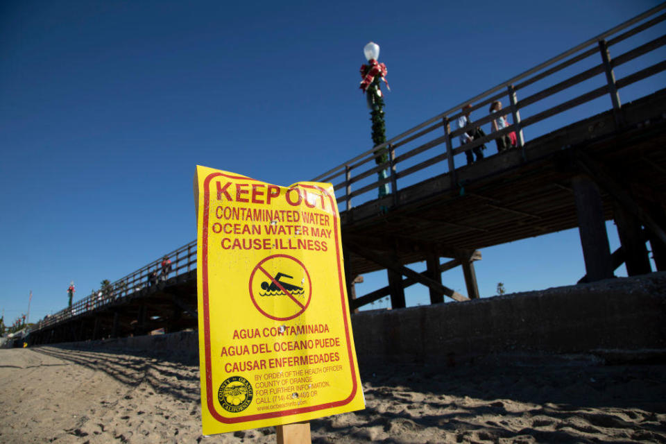 A Seal Beach Municipal Pier warns visitors to stay out of the water.  / Credit: Myung J. Chun