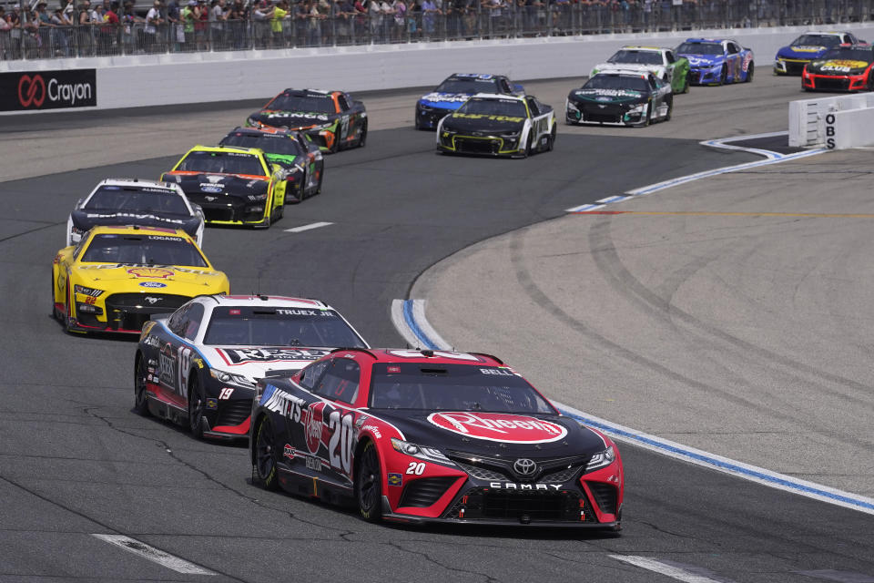 Pole-sitter Christopher Bell (20) leads the pack during the Crayon 301 NASCAR Cup Series race, Monday, July 17, 2023, at New Hampshire Motor Speedway, in Loudon, N.H. (AP Photo/Steven Senne)