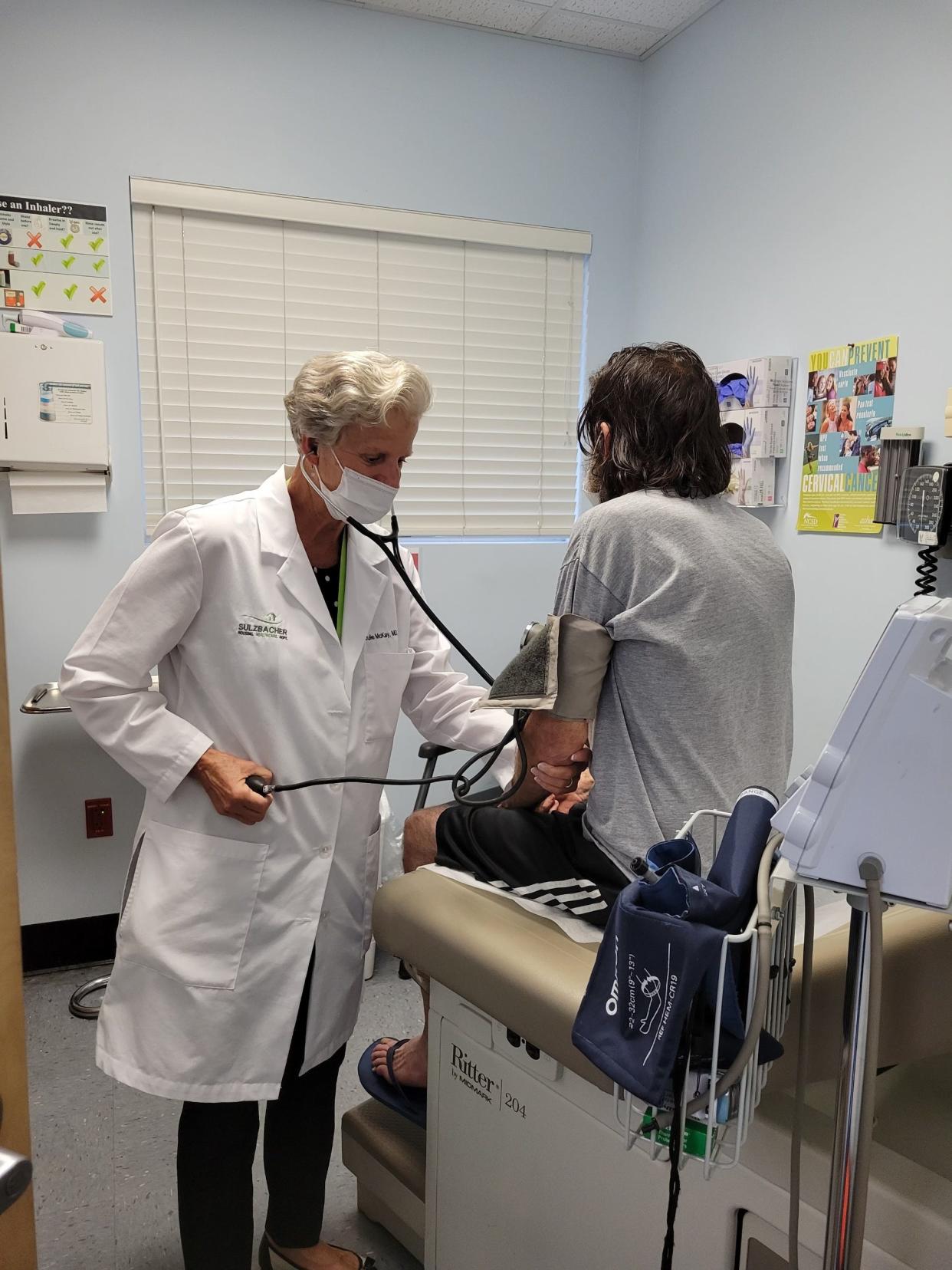 Dr. Julia McKay treats a patient at the Sulzbacher Center clinic, where she is the lead physician and works to meet the health needs of the unhoused in Jacksonville.