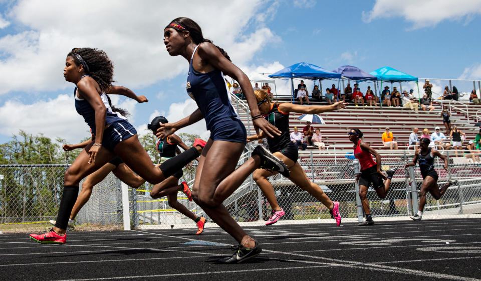 Loren Vargas Ojeda, left, of Naples High wins the 100 at the FHSAA Class 3A District-12 track and field meet at South Fort Myers High School on Saturday, April 23, 2022. Kayla Hopkins of Dunbar was second and Richcarnia Louis, foreground, was third.  