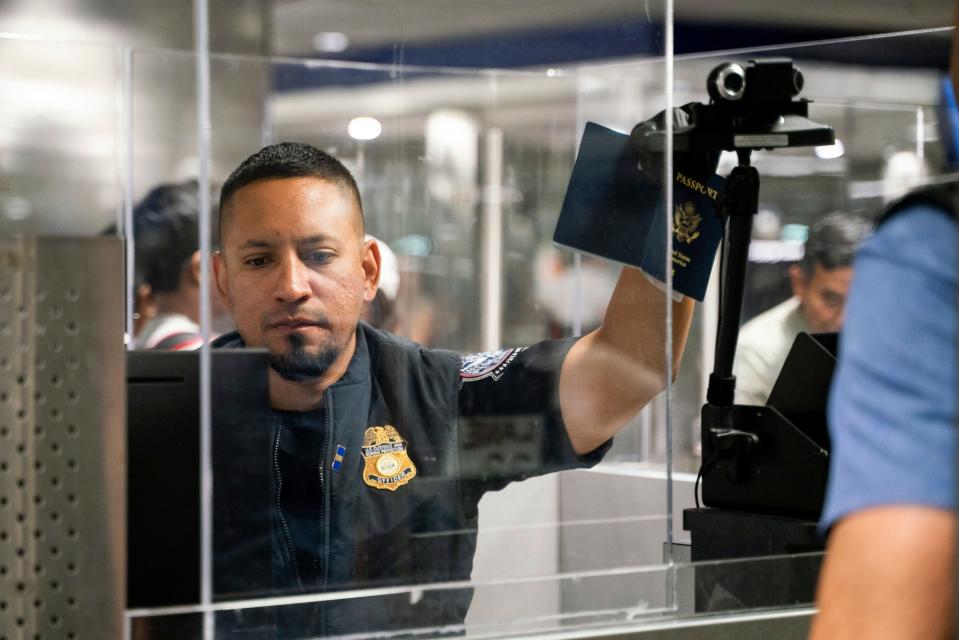 CBP officer J. Jimenez photographs an international traveler using facial recognition biometrics upon entering U.S. Customs and Border Protection at McNamara Terminal at Detroit Metro Airport in Romulus on July 28, 2023.