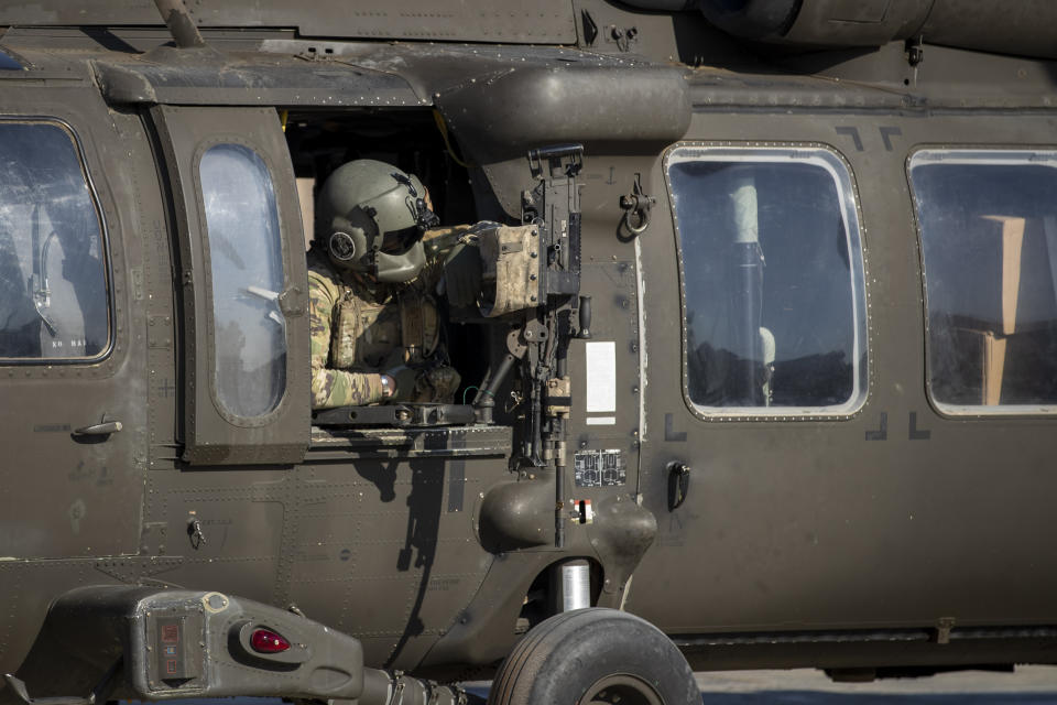 A helicopter gunner waits for takeoff at a US military base at an undisclosed location in Eastern Syria, Monday, Nov. 11, 2019. The deployment of the mechanized force comes after US troops withdrew from northeastern Syria, making way for a Turkish offensive that began last month. (AP Photo/Darko Bandic)
