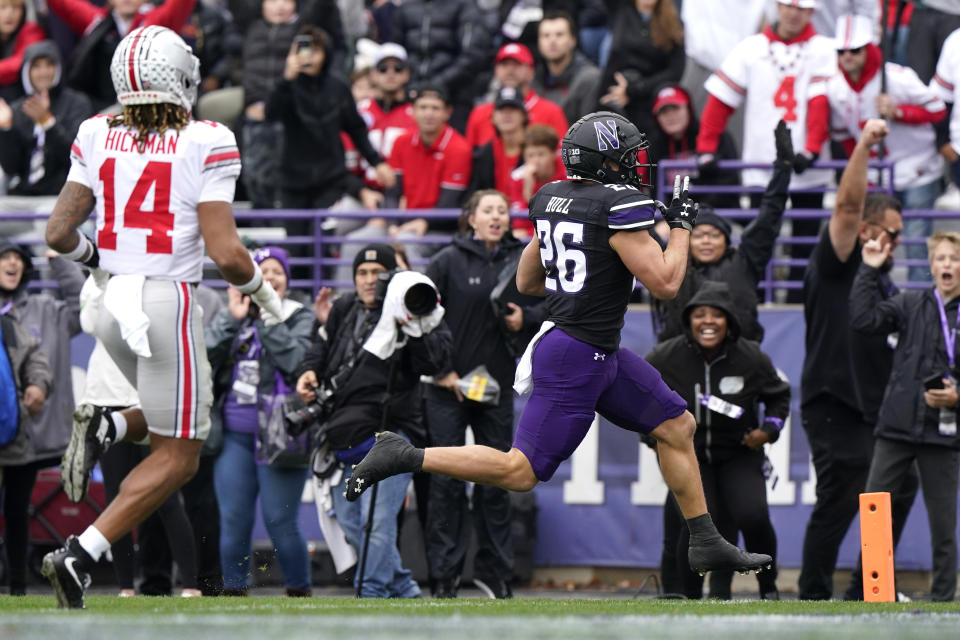 Northwestern running back Evan Hull, right, runs for a touchdown past Ohio State safety Ronnie Hickman during the first half of an NCAA college football game, Saturday, Nov. 5, 2022, in Evanston, Ill. (AP Photo/Nam Y. Huh)