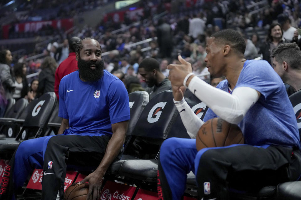 Los Angeles Clippers guard James Harden, left, and guard Russell Westbrook talk on the bench before the team's NBA basketball game against the Utah Jazz in Los Angeles, Friday, April 12, 2024. (AP Photo/Eric Thayer)