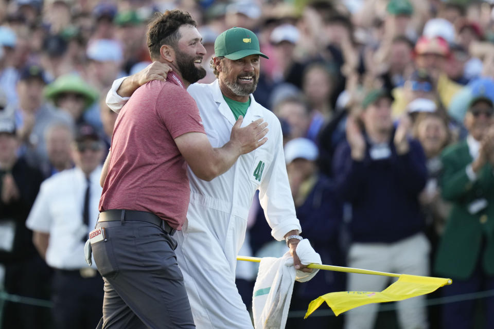 FILE - Jon Rahm, of Spain, embraces his caddie Adam Hayes holding the trophy after winning the Masters golf tournament at Augusta National Golf Club on April 9, 2023, in Augusta, Ga. Hayes is one of the few American caddies who works for a European player in the Ryder Cup. (AP Photo/Jae C. Hong, File)