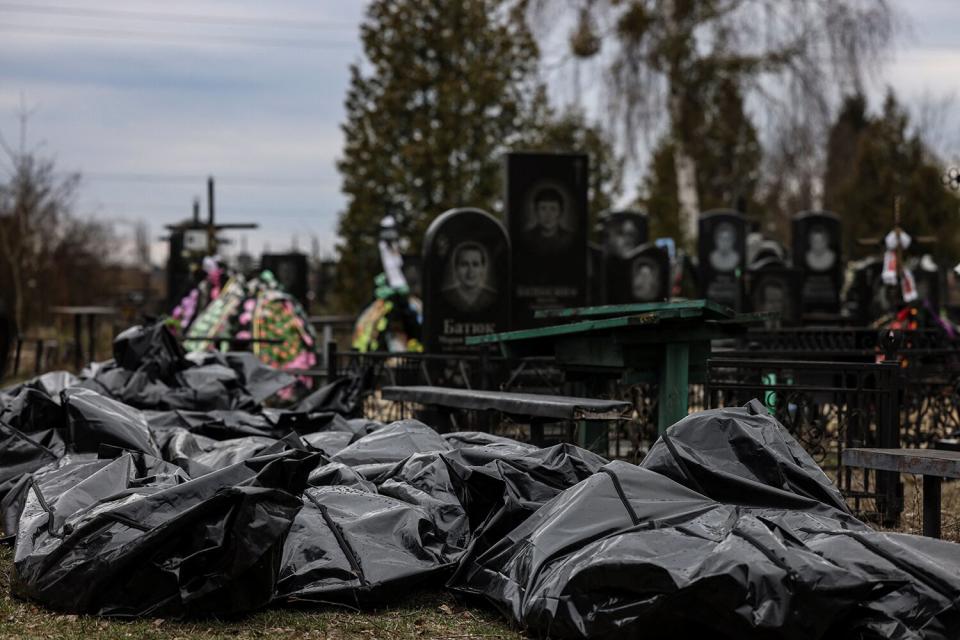 Body bags are lined up for identification by forensic personnel and police officers in the cemetery in Bucha, north of Kyiv, on April 6, 2022, after hundreds of civilians were found dead in areas from which Russian troops have withdrawn around Ukraine's capital, including the town of Bucha. - Located 30 kilometres (19 miles) northwest of Kyiv's city centre, the town of Bucha was occupied by Russian forces on February 27 in the opening days of the war and remained under their control for a month. After the bombardments stopped, Ukrainian forces were able to retake the town. Large numbers of bodies of men in civilian clothing have since been found in the streets.