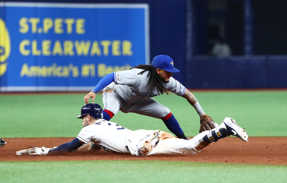 Aug 6, 2019; St. Petersburg, FL, USA; Tampa Bay Rays center fielder Kevin Kiermaier (39) doubles against Toronto Blue Jays shortstop Freddy Galvis (16) during the tenth inning at Tropicana Field. Mandatory Credit: Kim Klement-USA TODAY Sports