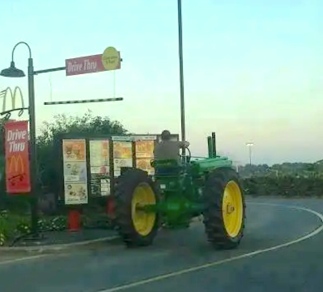 A tractor is queued at a McDonald's Drive-Thru, showcasing an unconventional vehicle choice for fast food