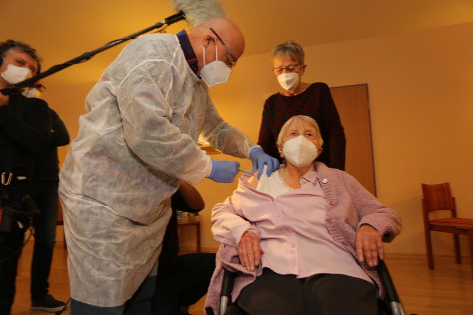 101-year-old Edith Kwoizalla, right, receives her second injection of the Pfizer/BioNTech vaccine against the COVID-19 disease from doctor Bernd Ellendt, center, at a retirement home in Halberstadt, German, Friday, Jan. 15, 2021. (Matthias Bein/dpa via AP)