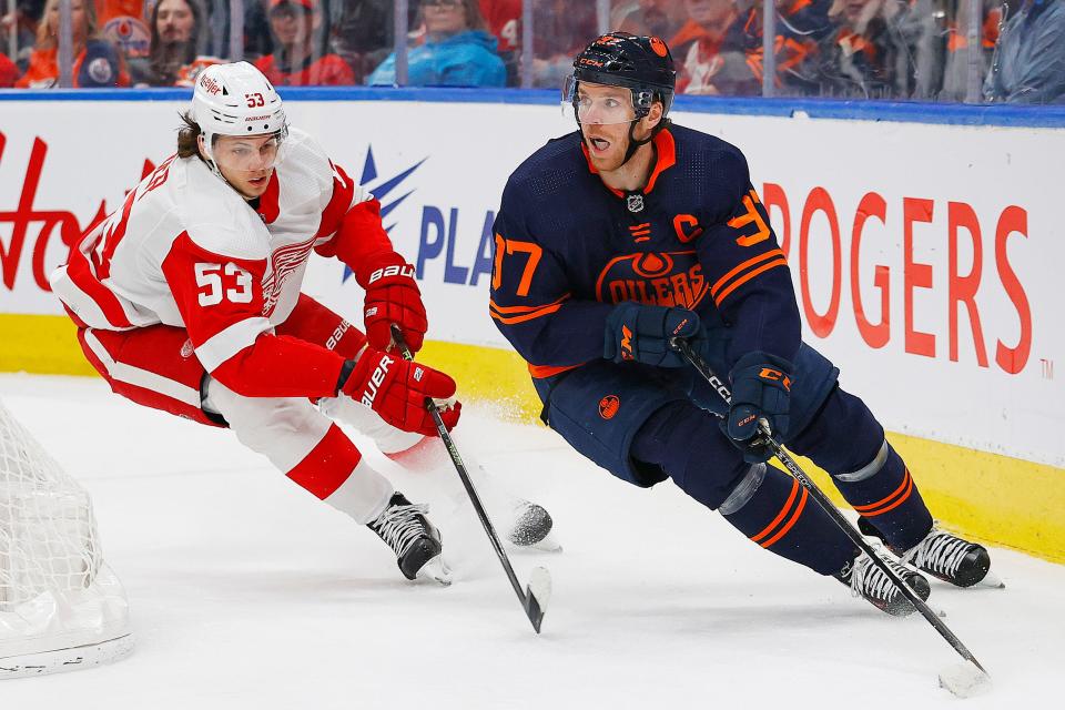 Edmonton Oilers forward Connor McDavid (97) protects the puck from Detroit Red Wings defensemen Moritz Seider (53) during the first period at Rogers Place in Edmonton on Wednesday, Feb. 15, 2023.