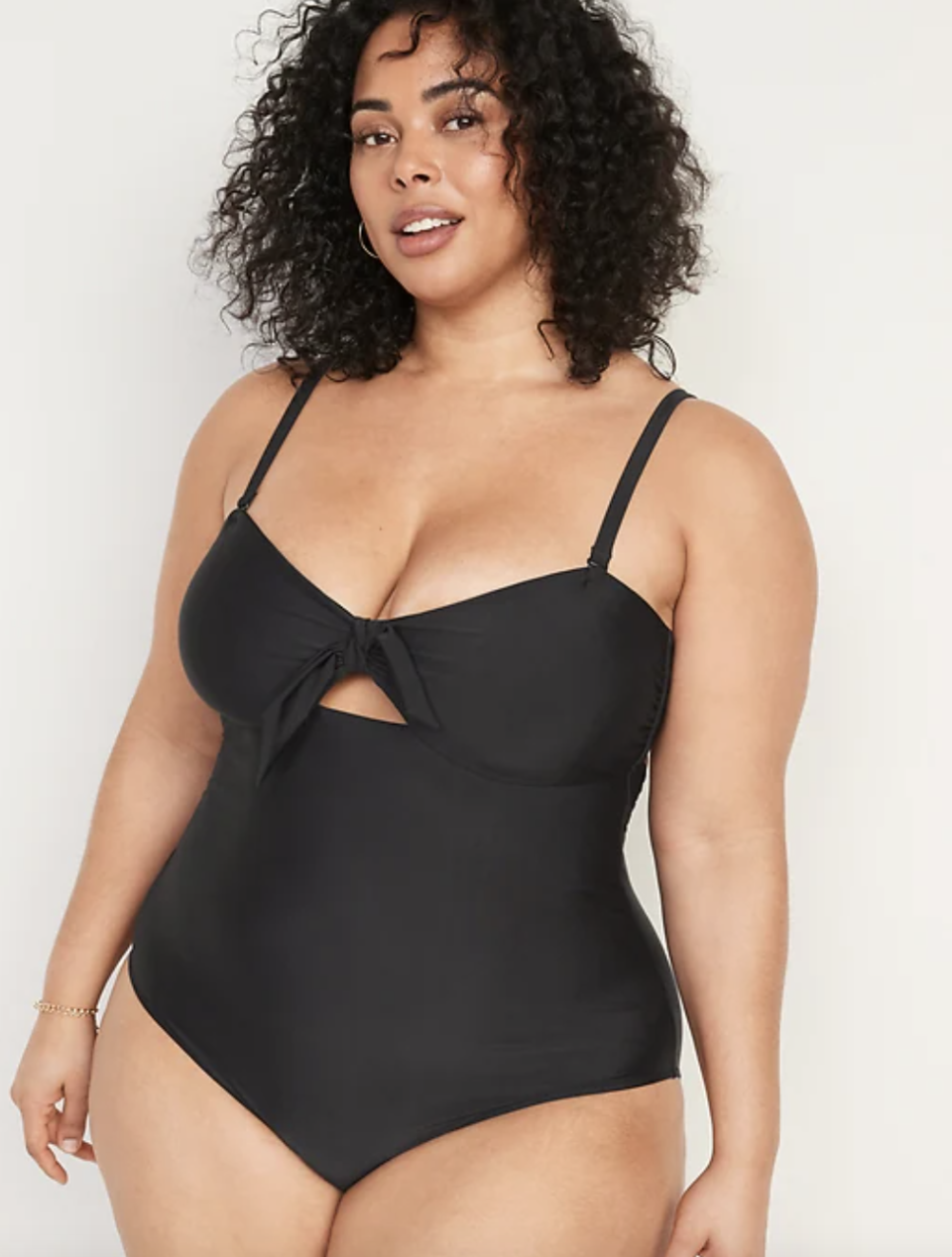 plus size model with curly hair in black Tie-Front Keyhole Bandeau-Style One-Piece Swimsuit (Photo via Old Navy)