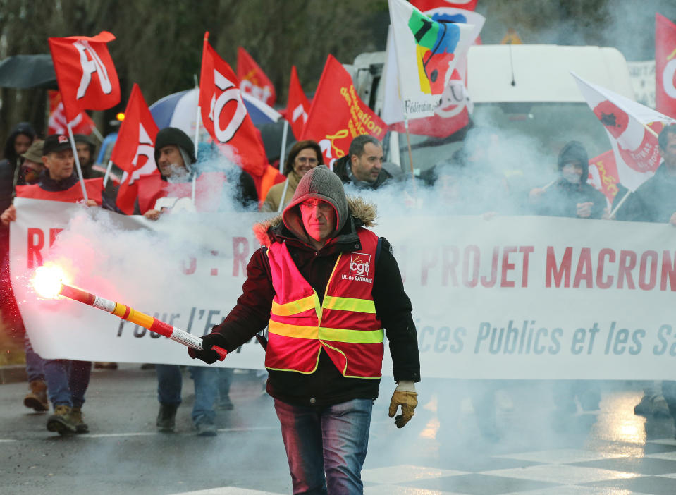 Un manifestante sindical sostiene una baliza durante una manifestación en Bayonne, suroeste de Francia, el jueves 12 de diciembre del 2019. (AP Foto/Bob Edme)