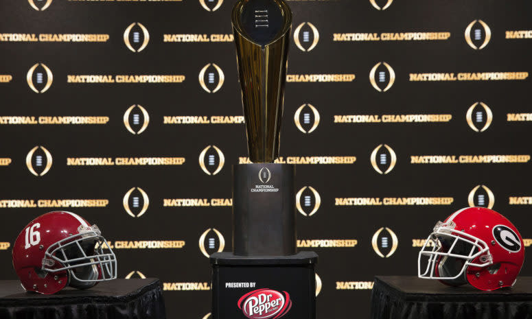 Detail of the College Football Playoff National Championship trophy, along with the helmets of the 2 competing teams, Alabama and Georgia.