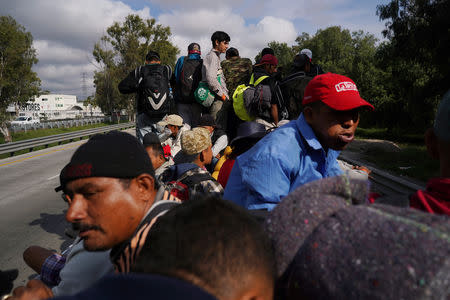 Migrants, part of a caravan of thousands traveling from Central America en route to the United States, sit on the back of a truck as they make their way to Queretaro from Mexico City, Mexico November 10, 2018. REUTERS/Go Nakamura