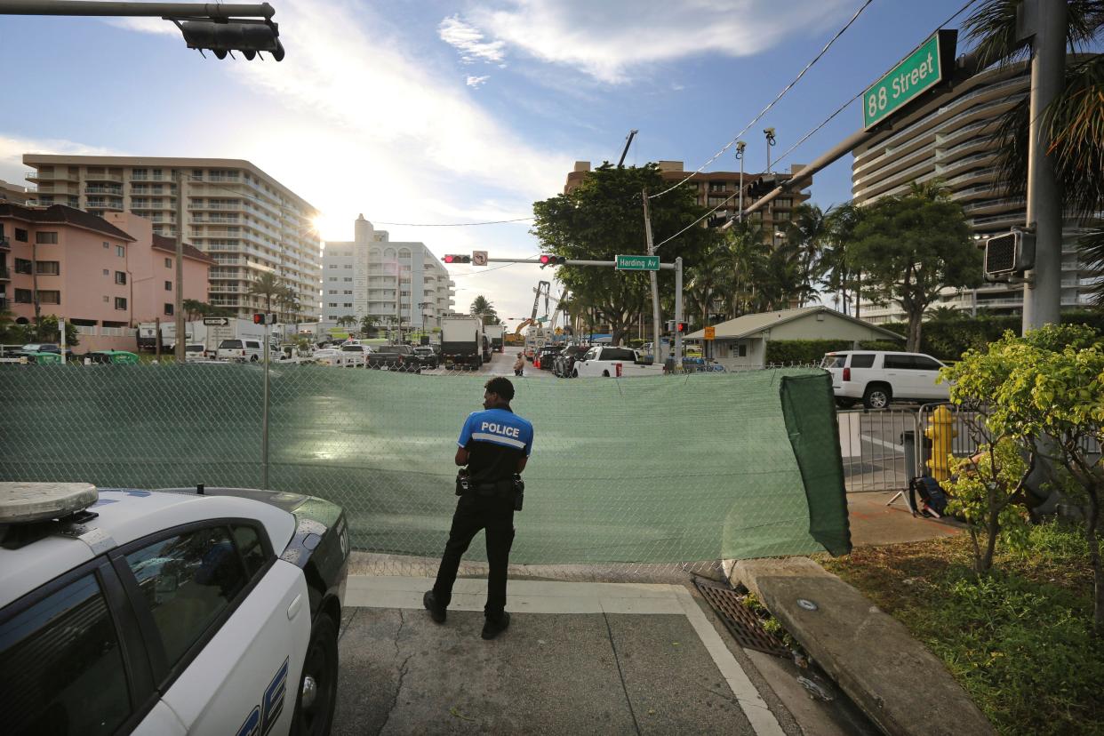 A police officer stands guard at the intersection of 88th St. and Harding Ave. near the Champlain Towers South Condo in Surfside, Fla., near Miami, on Monday, June 28, 2021.