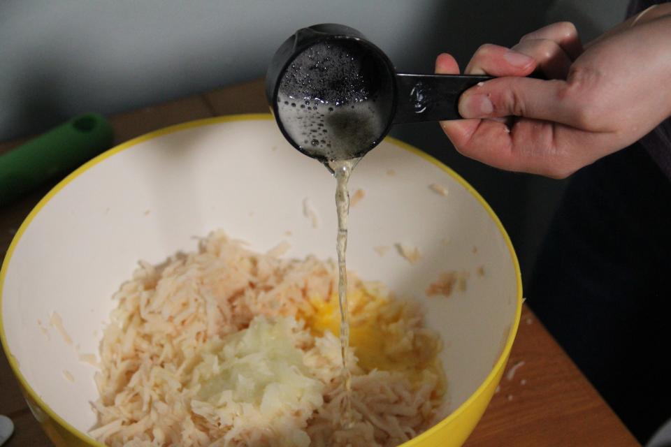 Pouring beer into a bowl of latke batter.