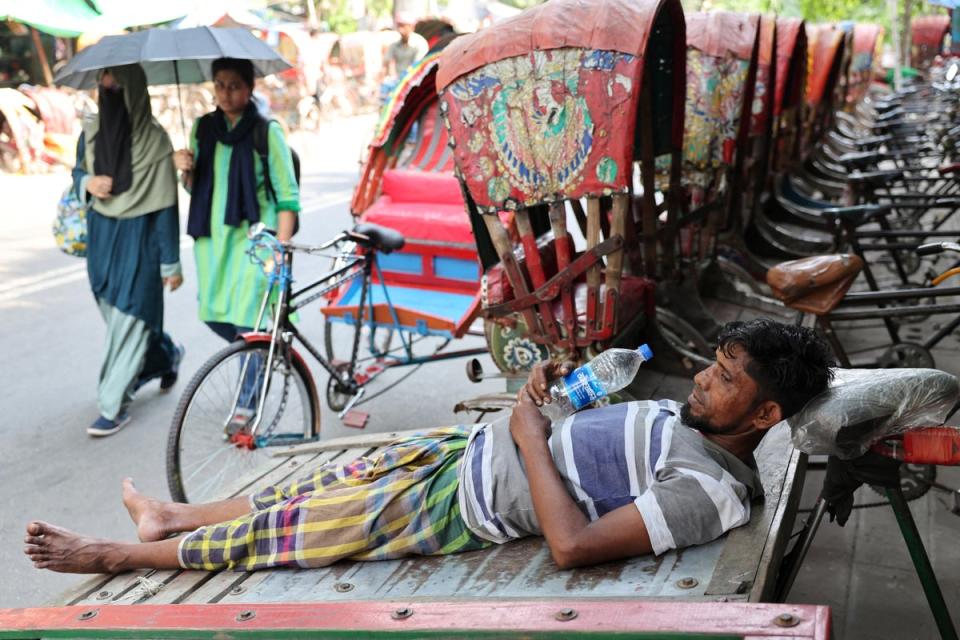 A man rests on a cart during a heatwave in Dhaka (Reuters)