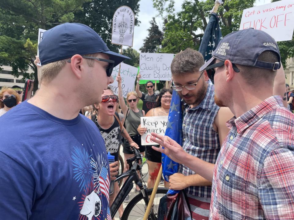 Anti-abortion counter-protesters and abortion rights protesters get into tense arguments at the state Capitol in Lansing on July 4, 2022.