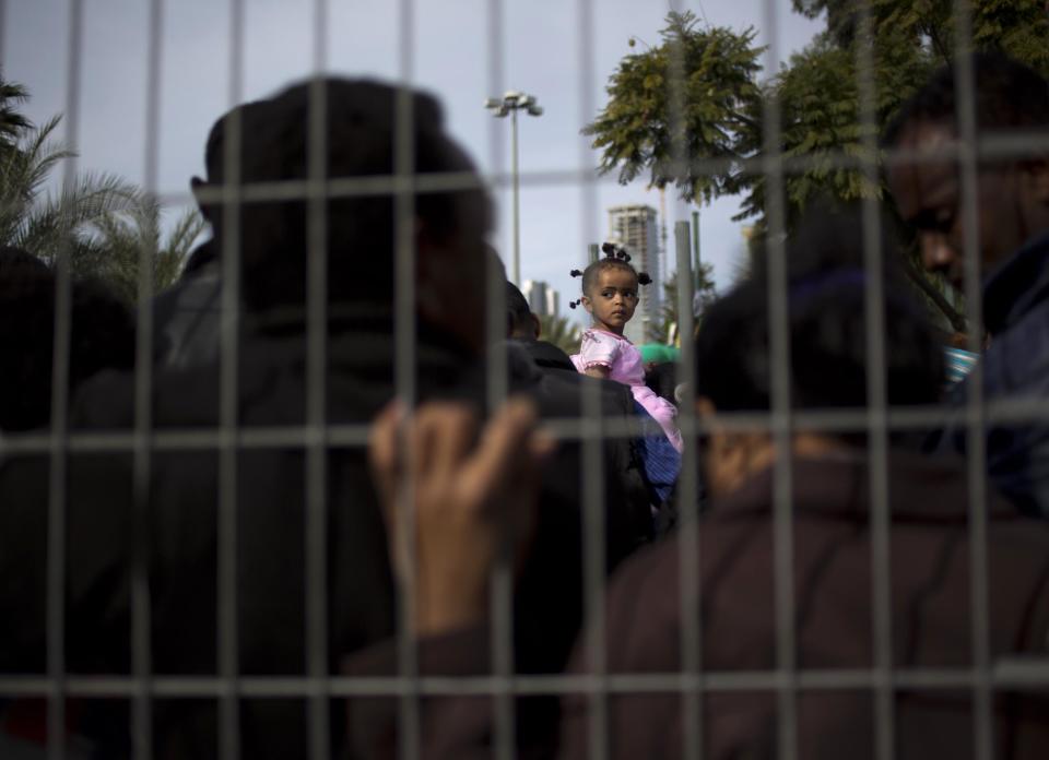 African migrants, one holding a girl on his shoulders, gather during a protest in Lewinsky park in Tel Aviv, Israel,Tuesday, Jan. 7, 2014. The migrants, some of whom are menial laborers in Israel, have been on a three-day strike. About 60,000 African migrants, mostly from Sudan and Eritrea, have trekked through Egypt and other Muslim countries to reach Israel in recent years. Some are fleeing violence or oppression in their home countries while others are seeking better economic opportunities. (AP Photo/Ariel Schalit)