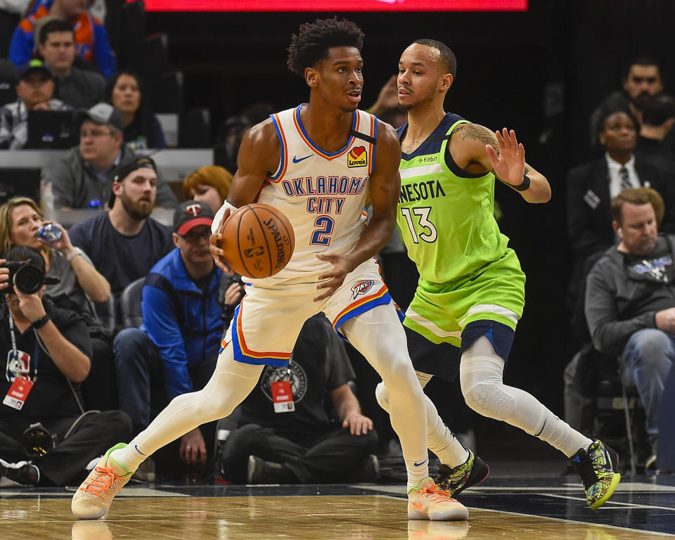 Oklahoma City Thunder guard Shai Gilgeous-Alexander (2) looks to pass the ball while defended by Minnesota Timberwolves guard Shabazz Napier (13) during the first half of an NBA basketball game Saturday, Jan. 25, 2020, in Minneapolis. (AP Photo/Craig Lassig)