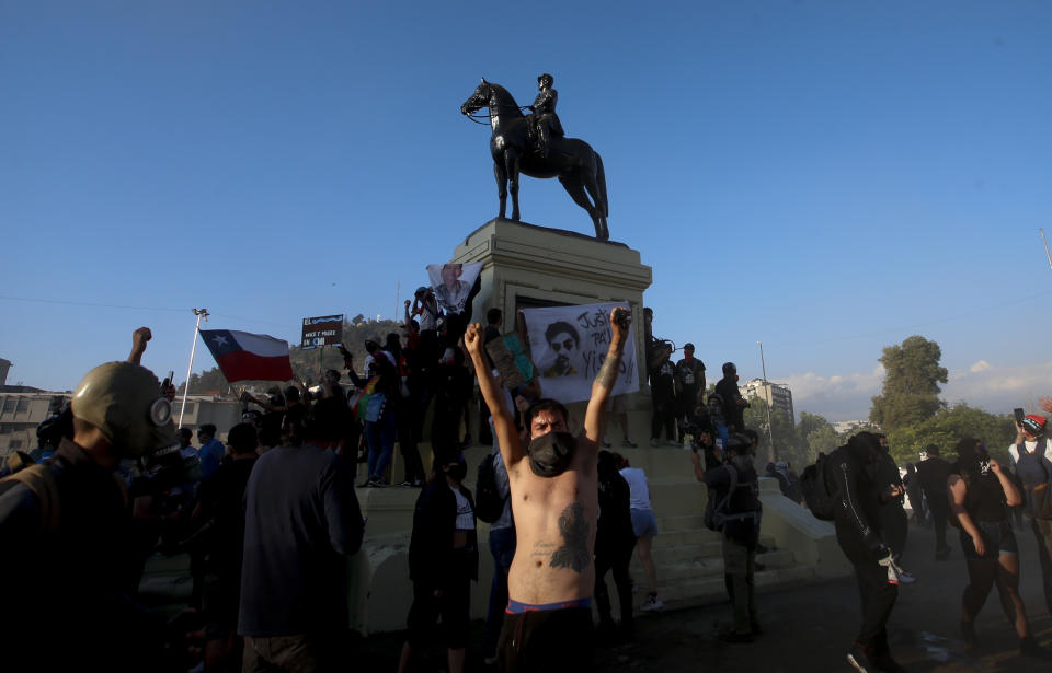 Un manifestante contra el gobierno levanta los brazos en la Plaza Italia después de un plebiscito para decidir si el país debe reemplazar su constitución de hace 40 años, redactada durante la última dictadura militar, en Santiago, Chile, el domingo 25 de octubre de 2020. (AP Foto/Luis Hidalgo)