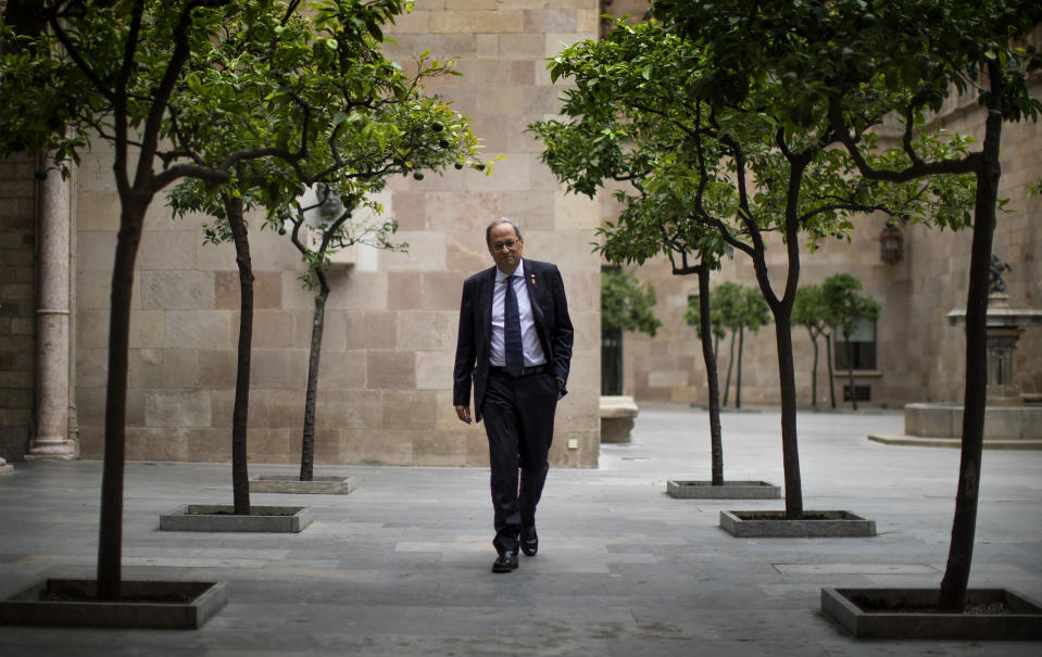 Catalan regional president Quim Torra walks at the Palace of the Generalitat, the headquarters of the Government of Catalonia, ahead of an interview with The Associated Press in Barcelona, Spain, Monday, Oct. 21, 2019. The leader of Catalonia says that the massive protests that have often spiralled into violent clashes with police this week won't cease until the Spanish government accepts to listen to separatists' demands. (AP Photo/Emilio Morenatti)