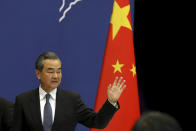 Chinese Foreign Minister Wang Yi waves as he leaves after a press conference on the upcoming Road and Belt Forum in Beijing on Friday, April 19, 2019. China is downplaying the political implications of its global development campaign known as the Belt and Road initiative, saying that it aims to boost multilateralism amid protectionist trends in the U.S. and elsewhere. (AP Photo/Ng Han Guan)