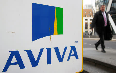 FILE PHOTO: A man walks past an AVIVA logo outside the company's head office in the city of London March 5, 2009. REUTERS/Stephen Hird/File Photo